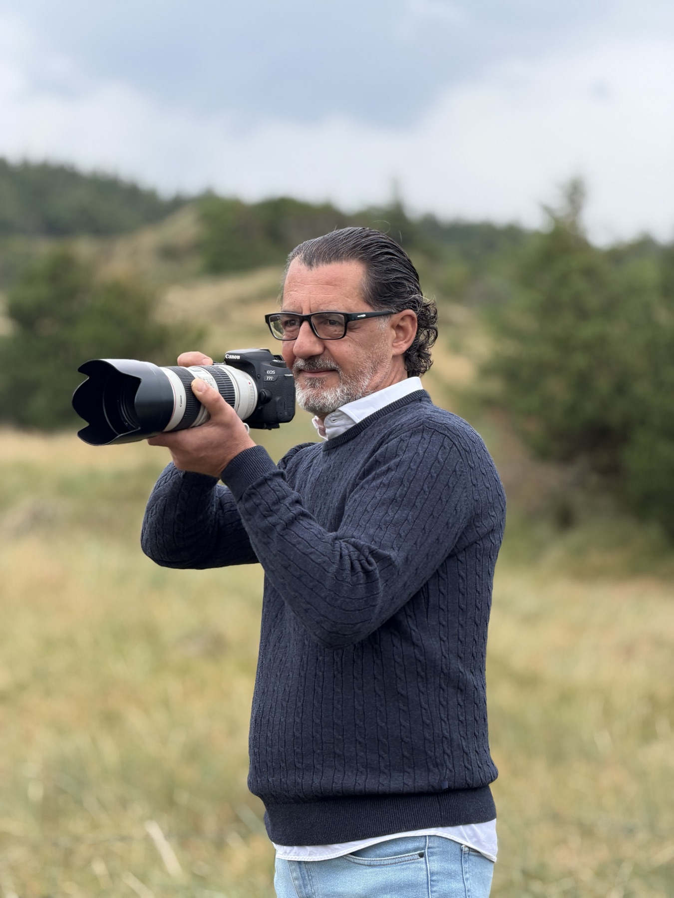 Mike Ceker holding his camera outdoors.